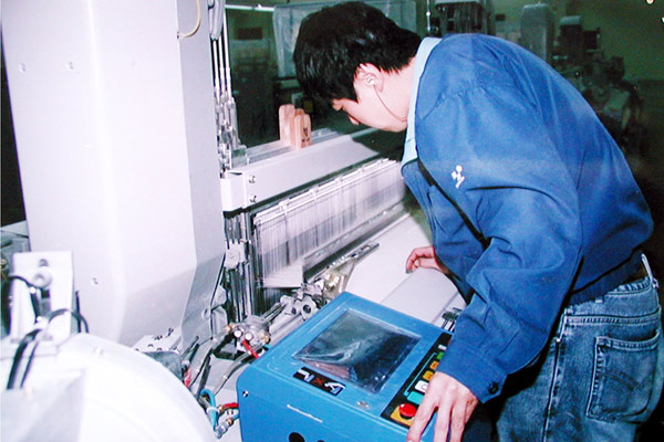 公司技工正在對(duì)布機(jī)進(jìn)行調(diào)試